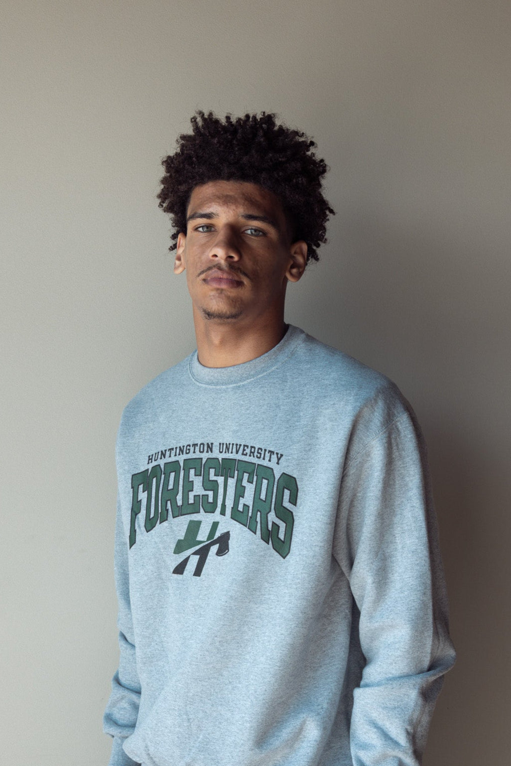 Man posing wearing a gray crew neck